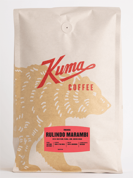 A bag of Kuma Coffee Rulindo Marambi whole bean coffee. The packaging is a cream-colored stand-up pouch with a red stylized 'Kuma' logo, a gold bear silhouette, and a red label at the bottom.